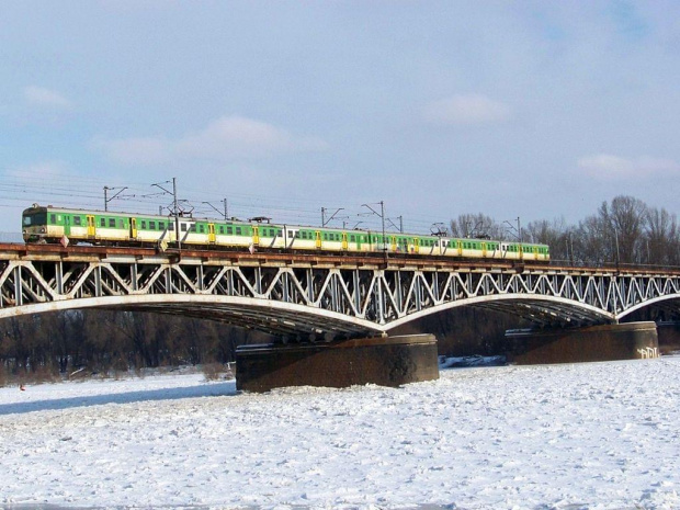Most kolejowy z zielonym pociągiem #Warszawa #Wisła #zima #śnieg #MostKolejowy #pociąg #EN57